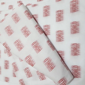 May include: White tissue paper with a repeating pattern of the words "Around the World Treats" in red. The text is stylized with a small graphic of a coffee cup and a laptop.