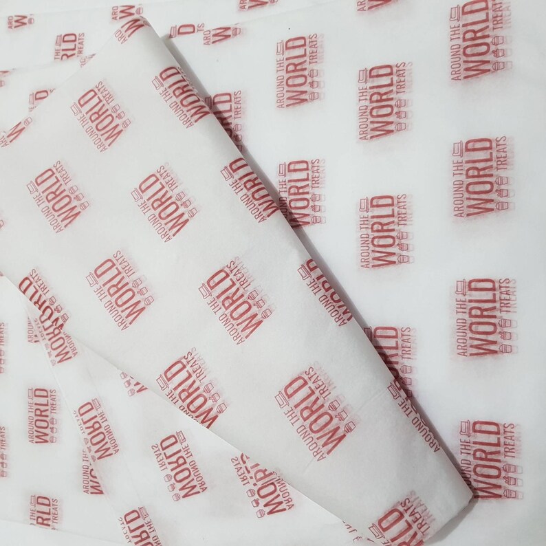 May include: White tissue paper with a repeating pattern of the words "Around the World Treats" in red. The text is stylized with a small graphic of a coffee cup and a laptop.