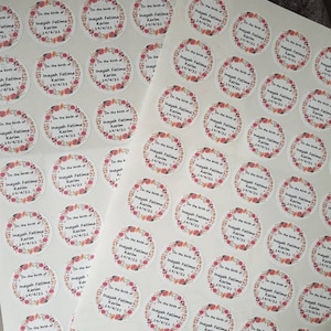 Może przedstawiać: Arkusz białego papieru z wieloma okrągłymi naklejkami z kwiatowym wzorem i tekstem "On the birth of Inayah Fatima Karim" z różnymi datami.