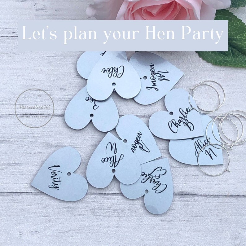 May include: Light blue heart-shaped tags with names written in black ink. The tags are scattered on a light wood surface. The text "Let's plan your Hen Party" is at the top of the image.
