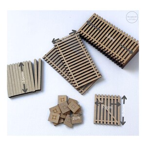 May include: A selection of miniature wooden fence pieces, gates, and small square tiles. The fences measure 7.5cm high and 13cm wide. The gate is 6.5cm high and 5.3cm wide. The small tiles are 2cm square. Suitable for crafting and model making.