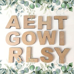 May include: A collection of twelve individual capital letters made of light brown, smooth-surfaced material. The letters arranged in three rows are A, E, H, T, G, O, W, I, R, L, S, and Y. Each letter features a clean, sans-serif block typeface.