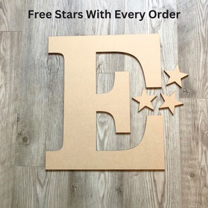 May include: A large, flat, tan-colored wooden letter E cutout accompanied by three smaller matching star-shaped cutouts. The text "Free Stars With Every Order" is printed in black at the top of the image, positioned above the letter and stars.