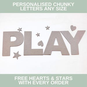 May include: Chunky gray letters spelling the word PLAY, accompanied by small gray star and heart shapes. The text PERSONALISED CHUNKY LETTERS ANY SIZE and FREE HEARTS & STARS WITH EVERY ORDER is displayed at the top and bottom of the image.