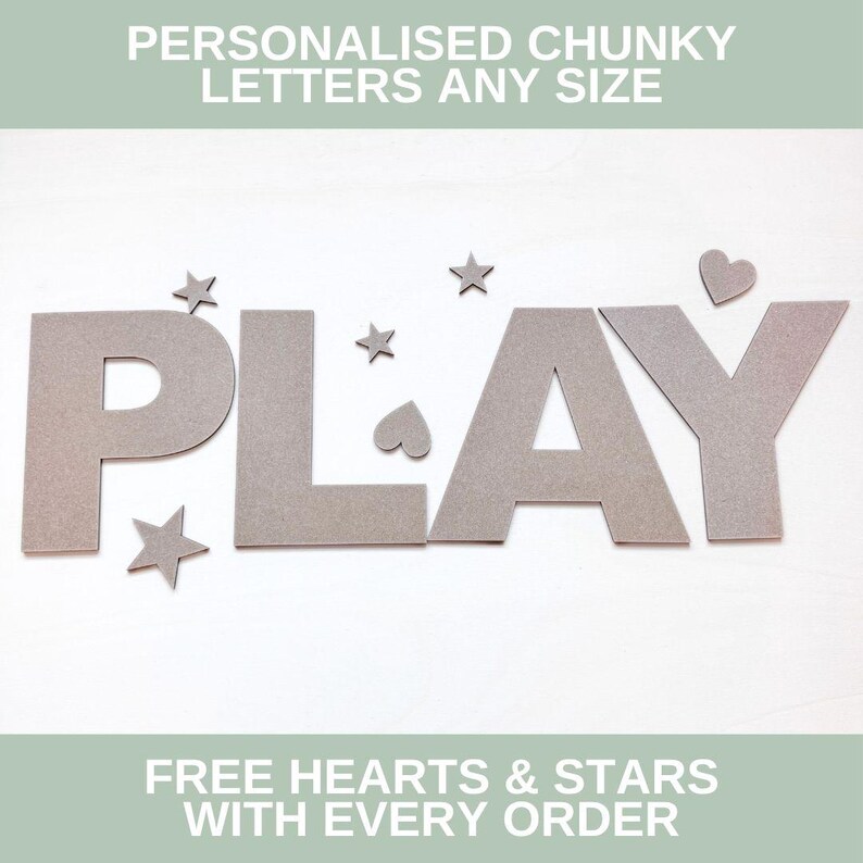 May include: Chunky gray letters spelling the word PLAY, accompanied by small gray star and heart shapes. The text PERSONALISED CHUNKY LETTERS ANY SIZE and FREE HEARTS & STARS WITH EVERY ORDER is displayed at the top and bottom of the image.