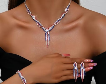May include: A sparkling jewelry set featuring a necklace, bracelet, and earrings. The necklace and bracelet have a braided design with red, white, and blue rhinestones. The earrings are teardrop-shaped, with matching red, white, and blue stones.