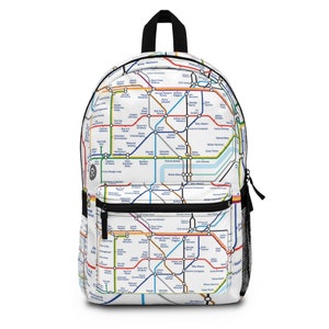 Puede incluir: Mochila blanca con un diseño colorido de mapa del metro. La mochila tiene un asa y cremallera negras, un bolsillo frontal y un bolsillo lateral de malla. El diseño del mapa incluye líneas de colores y nombres de estaciones.
