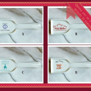 May include: Four white ceramic spoon rests with different designs. The first spoon rest has a blue chef hat and house with the text "Roath's Home Cooking". The second spoon rest has a red pot and house with the text "Home Kitchen Restaurant". The third spoon rest has a blue house with the text "The Jensen Family Kitchen". The fourth spoon rest has a red mixer with the text "Ally's Kitchen".