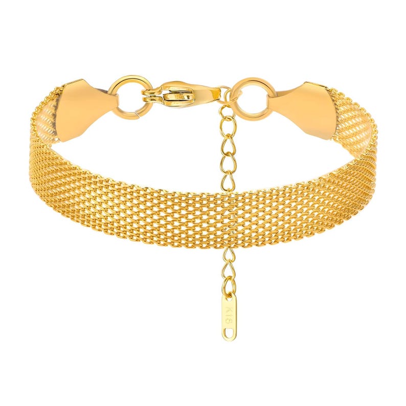 May include: A gold-tone mesh bracelet with a lobster clasp and a small charm hanging from the bottom.