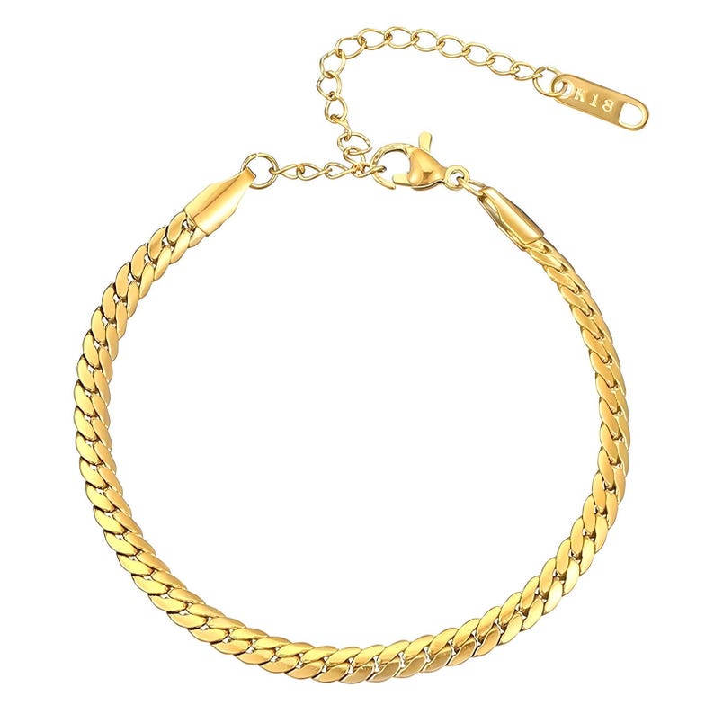 May include: A gold chain bracelet with a lobster clasp closure. The chain is a curb style with a flat, wide design.