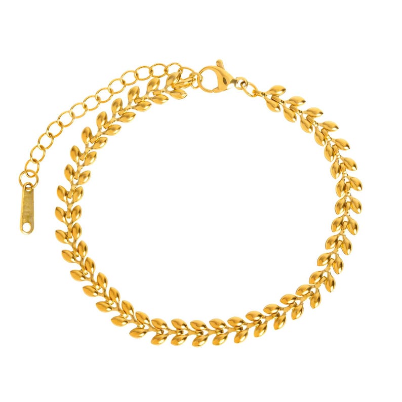 May include: A gold-toned anklet with a delicate chain and a leaf-shaped design.