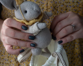 Interior knitted toy rabbit in a crown in the style of teddy toys with moving paws and head.