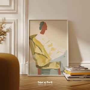May include: A framed art print featuring an abstract illustration of a person seated in a yellow armchair. The figure is depicted in profile with a red face and a green head covering. The print is labeled "Tiger of Paris, French Art Studio."