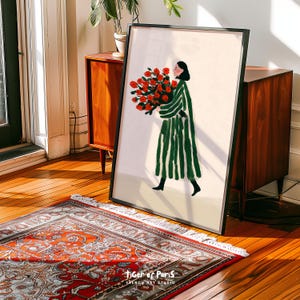 May include: Framed art print depicting a woman in a green striped coat holding a large bouquet of red roses. The artwork is set against a neutral background and is signed "Tiger of Paris, French Art Studio."