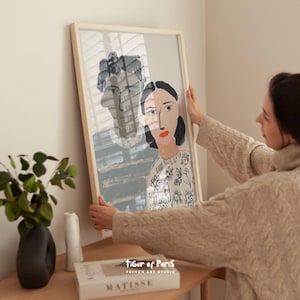 Peut inclure: Une tasse en céramique blanche avec une anse noire et le texte "But First, Coffee" en noir, dans une police manuscrite. La tasse est posée sur une surface blanche.