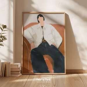 May include: A framed art print featuring a minimalist illustration of a person in a white shirt and dark pants seated on a rust-colored sofa. The artwork is set against a neutral wall, with the text "TIGER of PARIS FRENCH ART STUDIO" at the bottom.