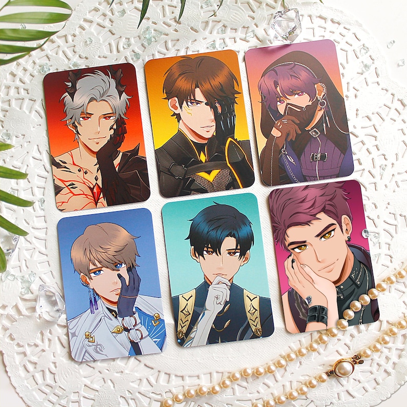 May include: Six rectangular trading cards featuring anime-style illustrations of characters. The top row shows a character with red eyes and horns, a brown-haired character in armor, and a purple-haired character in a hood. The bottom row shows a character with blue eyes, a dark-haired character, and a character with magenta hair.