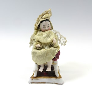 Museum antique porcelain mechanical Frozen charlotte or Tauffling doll sitting in chair