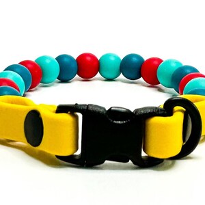 Breakaway bead cat collar made with dark teal, red and teal silicone beads paired with yellow biothane.