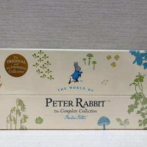 May include: A cream-colored box set featuring illustrations and text from "The World of Peter Rabbit." The box has a Peter Rabbit character illustration, floral and mushroom designs, and the text "The Complete Collection" by Beatrix Potter.