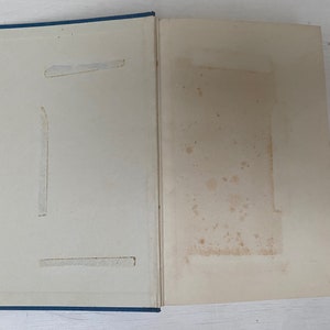 May include: A blue hardcover book with a white interior. The book has a few small stains on the inside cover.