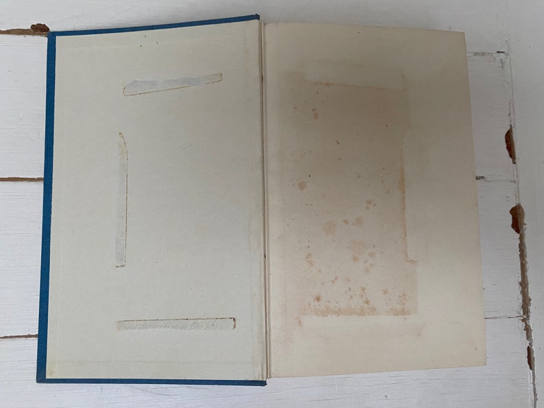 May include: A blue hardcover book with a white interior. The book has a few small stains on the inside cover.