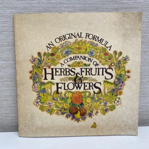 May include: A vintage book cover with a yellowed background and a wreath of colorful flowers, fruits, and herbs. The text reads "An Original Formula A Companion of Herbs Fruits & Flowers".