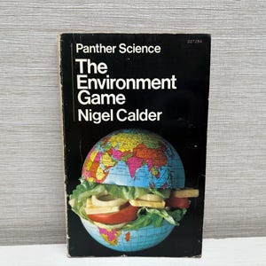 Puede incluir: Una portada de libro en blanco y negro con el título "The Environment Game" de Nigel Calder. La portada presenta un globo terráqueo con una ensalada verde encima.