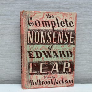 May include: A hardcover book titled The Complete Nonsense of Edward Lear, edited by Holbrook Jackson. The cover features a pale green and coral pink color scheme with intricate line-drawn illustrations of various animals and decorative patterns.