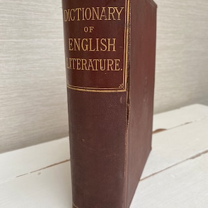 Puede incluir: Un libro encuadernado en cuero marrón titulado "Dictionary of English Literature".