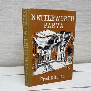 Könnte beinhalten: Ein braunes Buch mit dem Titel "Nettleworth Parva" von Fred Kitchen. Der Umschlag zeigt eine Schwarzweißillustration einer Dorfstraße mit Häusern.