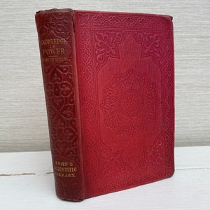 May include: A red hardcover book with gold lettering on the spine. The title is "Knowledge is Power" by Charles Knight. The book is part of Bohn's Scientific Library.