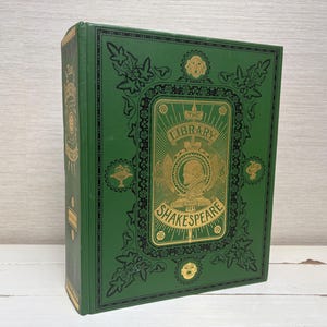 May include: A green hardback book with gold lettering. The title is "The Library of Shakespeare".