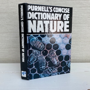 Peut inclure: Un livre noir intitulé "Purnell's Concise Dictionary of Nature" avec une image en gros plan d'abeilles sur un nid d'abeilles sur la couverture.