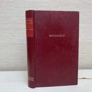 Może przedstawiać: Burgundowa książka w twardej oprawie ze złotymi napisami na grzbiecie i okładce. Grzbiet zawiera napis "Giovanni Boccaccio Das Decameron". Okładka zawiera napis "Boccaccio".