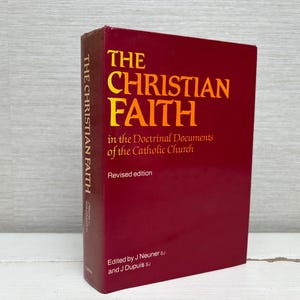May include: A maroon book titled "The Christian Faith" with gold lettering. The book's spine reads "The Christian Faith." The cover also includes the text "in the Doctrinal Documents of the Catholic Church" and "Revised edition."