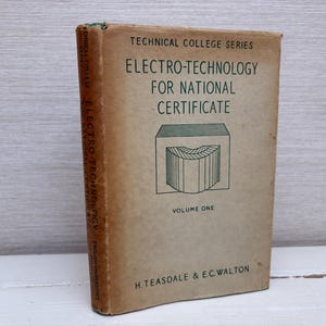 Op de afbeelding: Een bruin boek met de titel "Electro-Technology for National Certificate, Volume One". Het maakt deel uit van de "Technical College Series" en is geschreven door H. Teasdale & E.C. Walton.