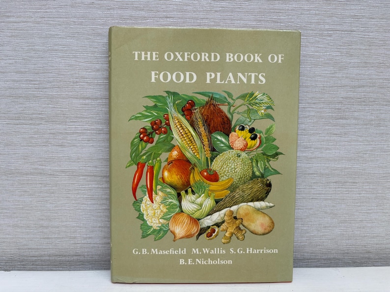May include: A vintage book titled "The Oxford Book of Food Plants" with a green cover. The cover features a colorful illustration of various fruits and vegetables, including corn, tomatoes, and bananas. The authors' names are listed at the bottom.
