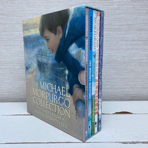 Op de afbeelding: Een boxset van vijf boeken getiteld 'The Michael Morpurgo Collection'. De box en de ruggen van de boeken zijn in verschillende kleuren. Titels zijn onder meer 'This Morning I Met a Whale' en 'The Mozart Question'. De box toont een jongen die naar het water kijkt.