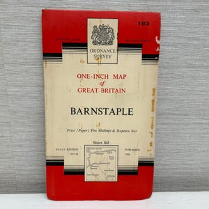May include: A vintage Ordnance Survey One-Inch Map of Great Britain, Barnstaple. The map features a red cover with black detailing and text. Fully revised in 1957-58 and published in 1960. The map is approximately 25 cm tall.