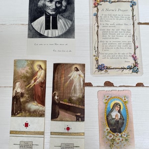 May include: Collection of vintage religious cards and bookmarks. Includes a black and white portrait, a prayer card with floral borders, and several bookmarks with religious imagery. The bookmarks feature gold accents and French text.