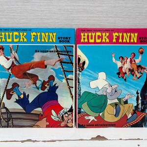 Può includere: Due libri di storie vintage "Le nuove avventure di Huck Finn". Le copertine presentano illustrazioni colorate di personaggi e scene dello show televisivo, con la scritta "As seen on television".