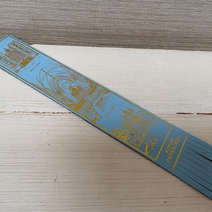 May include: A light blue bookmark with gold illustrations of a cathedral. The bookmark has the words "West Front" and "Ripon Cathedral" printed on it. The bottom of the bookmark has a fringe.