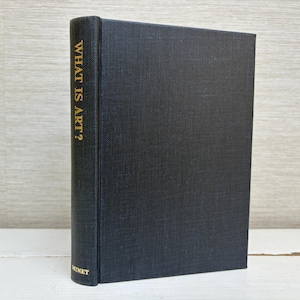 May include: A black hardcover book with gold lettering on the spine that reads "WHAT IS ART?" and the word "MENET" at the bottom of the spine.