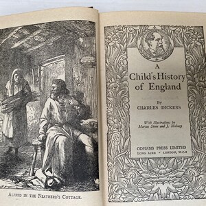 May include: Open book with illustrations. The left page shows a black and white drawing of a man and woman in a cottage. The right page has the title "A Child's History of England" by Charles Dickens, with illustrations by Marcus Stone and J. Mabury.