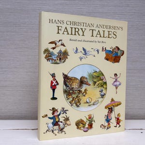May include: A vintage hardcover book titled "Hans Christian Andersen's Fairy Tales." The cover features colorful illustrations of ducks, a ballerina, and other fairytale characters. The book is cream-colored with text and illustrations.