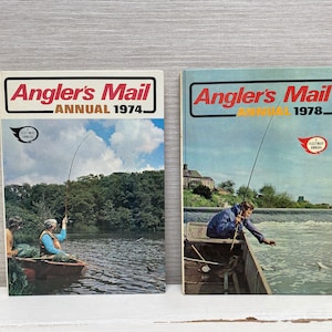 Könnte beinhalten: Zwei Vintage-Ausgaben von Angler's Mail Annual, eine aus dem Jahr 1974 und eine aus dem Jahr 1978. Beide Cover zeigen Illustrationen von Menschen, die an einem Fluss angeln.