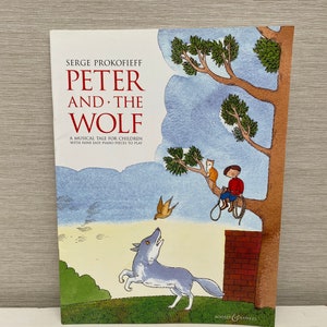 May include: A book cover with a blue sky background and a wolf howling at a bird. The title of the book is "Peter and the Wolf" by Serge Prokofieff. The book is a musical tale for children with nine easy piano pieces to play.