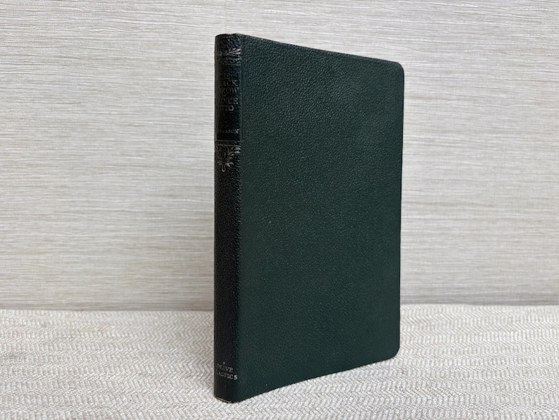 May include: A dark green hardcover book with the title visible on the spine. The book has a textured cover and appears to be in good condition. The book is standing upright on a light-colored surface.