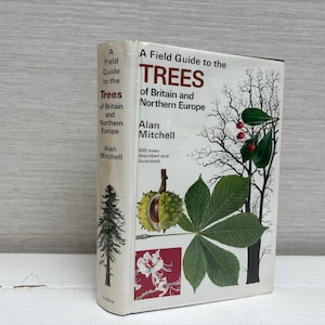 Könnte beinhalten: Ein gebundenes Buch mit dem Titel "A Field Guide to the Trees of Britain and Northern Europe" von Alan Mitchell. Das Cover zeigt Illustrationen von Bäumen, Blättern und einer Kastanie. Ein Leitfaden zur Baumbestimmung.